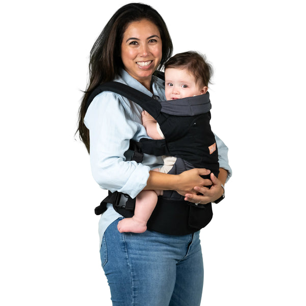 Mom is carrying her child in the 
Caleo 3-in-1 Newborn Carrier