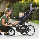 Load image into gallery viewer, Mom is interacting with her child sitting in the Baby Trend XCEL-R8 PLUS Jogger Stroller with LED