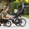 Mom is interacting with her child sitting in the Baby Trend XCEL-R8 PLUS Jogger Stroller with LED