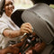 A mother is adjusting the canopy on the Baby Trend Cover Me Convertible Car Seat to block the sun on her child face while driving