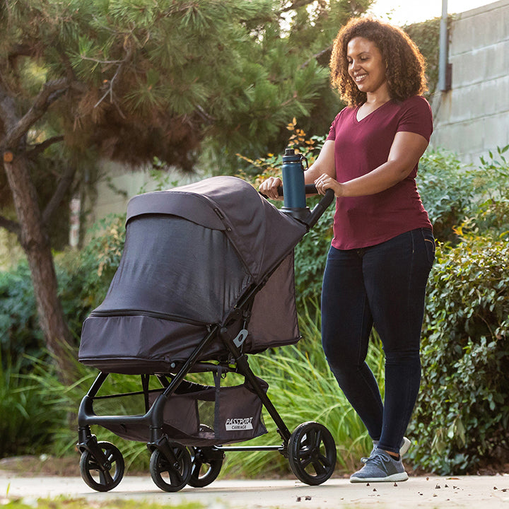 A mom is pushing her child sitting in a Baby Trend stroller